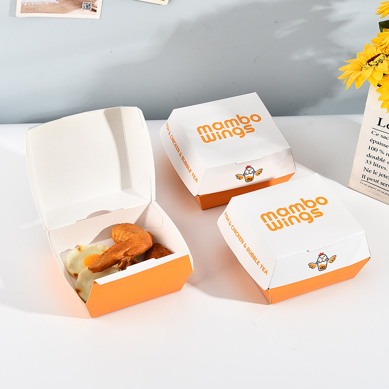 White paper boxes with orange printed artwork, showing one open box and two closed boxes